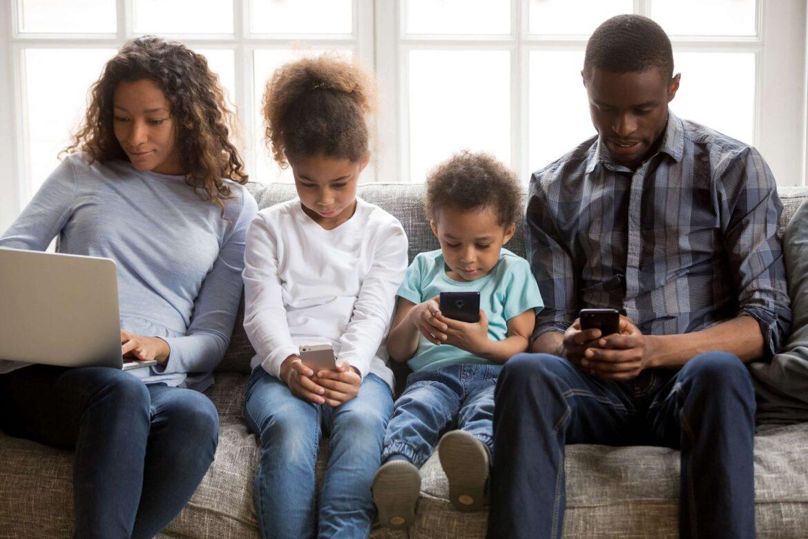 African,American,Family,With,Kids,Using,Laptop,And,Mobile,Phones